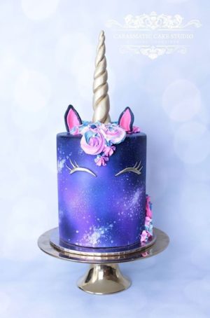 Quinceanera image of a purple unicorn birthday cake with a unicorn face on top