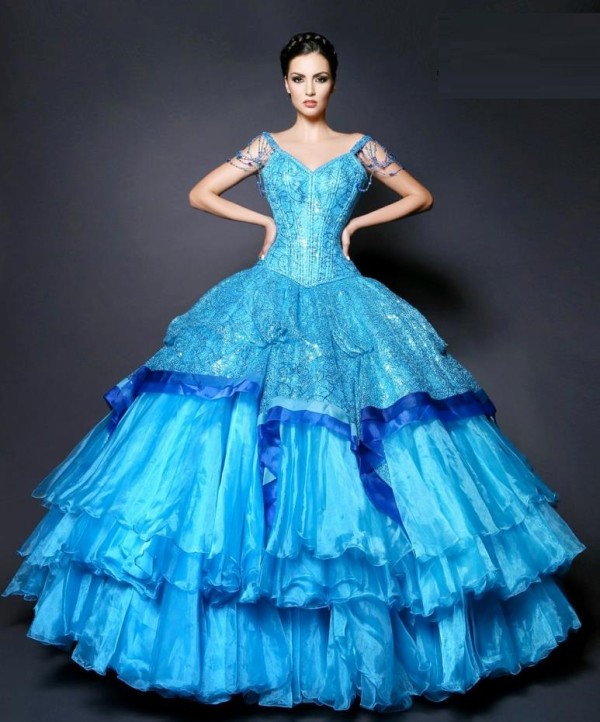 Quinceanera gown, a woman in a blue dress posing for a picture