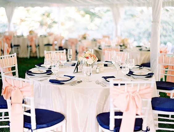 A table set up for a Quinceanera reception with navy blue and peach decor