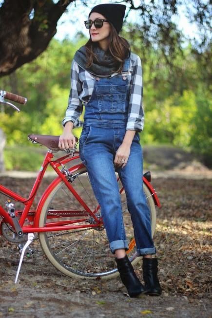 A woman wearing denim jeans sitting on a red bike at a Quinceanera celebration.