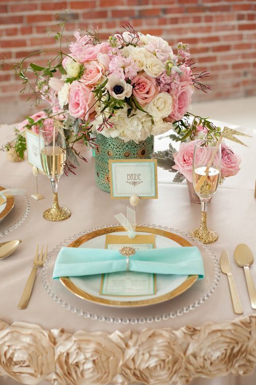 A pink and blue Quinceanera theme Quinceañera table setting with a gold plate.