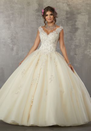 Quinceañera dresses for light skin, a woman in a Quinceanera dress standing in front of a wall