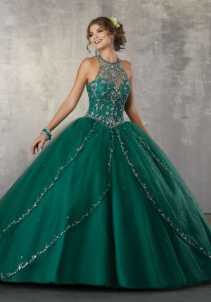 A woman in a green and silver quinceanera gown posing for a picture