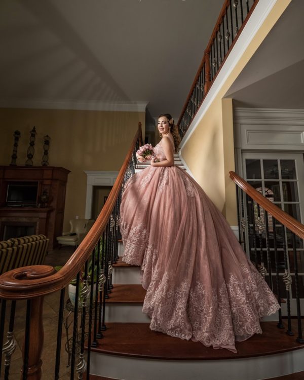 A woman in a Quinceanera gown standing on a staircase