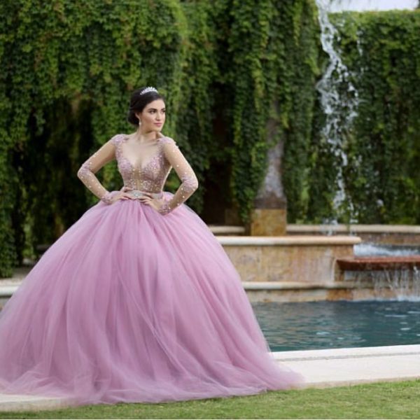 Quinceanera: Gown, a woman in a pink dress standing in front of a fountain