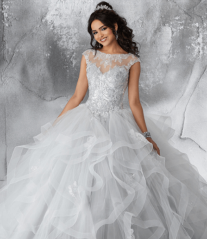 A woman in a silver with white quinceanera dress posing for a picture