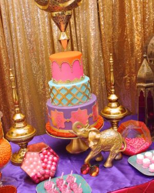 A Quinceanera cake decorated with pink and blue frosting on a table