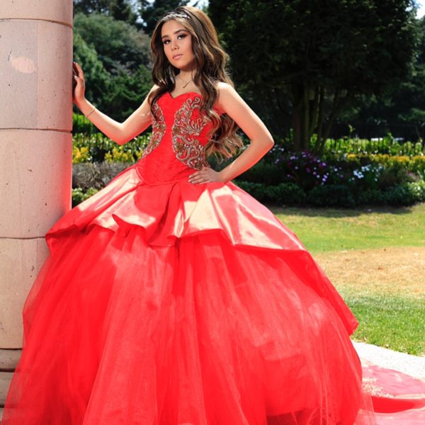 Quinceanera gown: a woman in a red dress posing for a picture