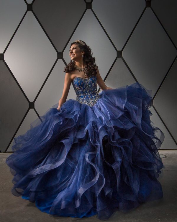 A woman in a blue gown posing for a picture in Quinceañera dresses