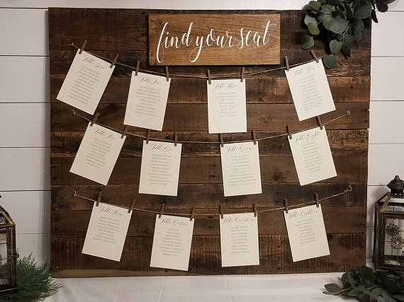 A wooden sign that says 'Find your seat', perfect for a Quinceanera event