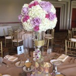 Quinceanera centrepiece, a table with a vase of flowers on top of it