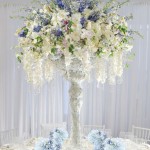 Quinceanera table with a tall white floral centerpiece