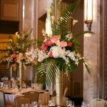 A Quinceanera Flora centerpiece, featuring a large vase with flowers atop a table.
