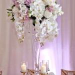 A Quinceanera clarinet vase centerpiece table, featuring a tall vase filled with white and pink flowers