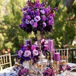 Quinceanera centerpiece, a table topped with fall purple flowers and candles