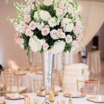 A tall vase filled with white and pink flowers, serving as a beautiful centerpiece for a Quinceanera celebration.