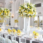 Quinceanera pastel yellow table decor centrepiece, a long table with white chairs and yellow flowers