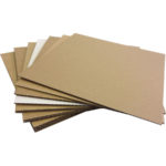A stack of brown envelopes made of corrugated fiberboard, sitting on top of each other on a KG sheet of paper