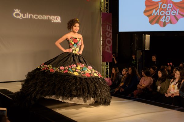 Quinceanera fashion show: a woman in a black dress on a runway