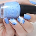 Quinceanera themed image featuring blue flower nail art ideas. The image shows a person holding a bottle of nail polish.