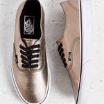 A pair of walking shoe Vans, gold sneakers on a white surface, perfect for a Quinceanera