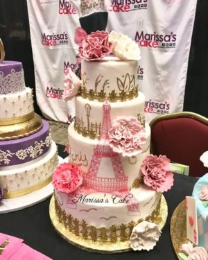 Quinceanera cake decorating: A table topped with three tiered cakes covered in frosting
