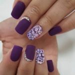 A Quinceanera image featuring a woman's hand with purple nails showcasing a purple manicure and nail designs