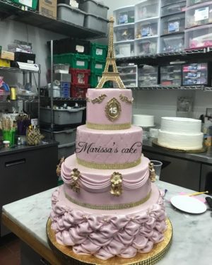A Quinceanera buttercream cake, a three-tiered cake sitting on top of a counter