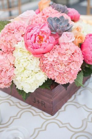A Quinceanera flower bouquet displayed in a vase filled with pink and white flowers