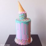 A colorful Quinceanera cake with a cone on top, perfect for ice cream lovers