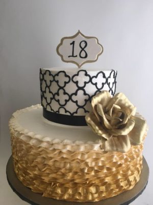 A Quinceanera themed sugar cake Cupcake featuring a three-tiered design with a gold rose on top
