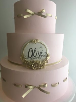 Quinceanera cake Cupcake, a three tiered cake with a gold bow decoration