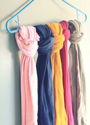 A collection of Quinceanera themed items including organizing tights, leggings, and a bunch of scarves hanging on a blue hanger