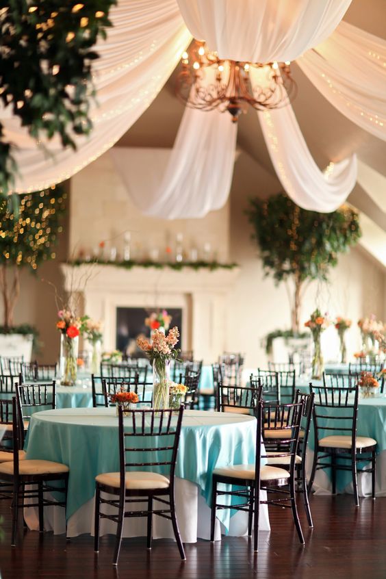 A Quinceanera function hall table with a room filled with lots of tables and chairs