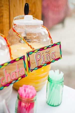 A Quinceanera-themed image showing a beautiful display of decoracion puesto de aguas frescas Mexican cuisine, including various types of juices and fruits.