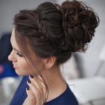 A woman with the most beautiful bun hairstyle, a messy bun in her hair for a Quinceanera