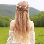 A woman with long blonde hair standing in a field, showcasing an elegant Quinceanera hairstyle.