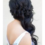 A woman with long black hair and a white tank top, wearing a side-swept braid hairstyle for a Quinceanera celebration