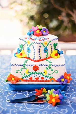A Mexican theme cake Cupcake, a white cake with colorful flowers on a blue table