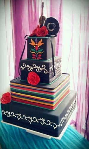 A Quinceanera cake featuring a three-tiered design with a guitar placed on top