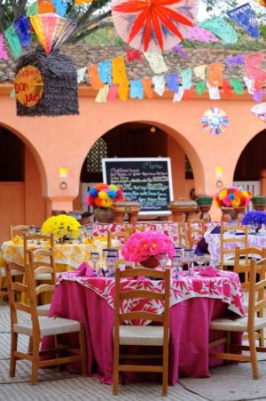 Quinceañera dresses with a table set up for a Mexican themed party in a charro quinceanera theme