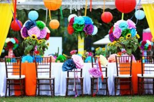 Quinceanera, a table with a bunch of colorful paper flowers in a multi color theme