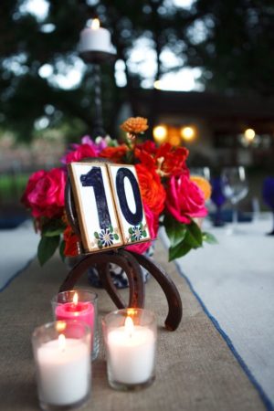 A lighting Quinceañera featuring a table with candles and a table number.