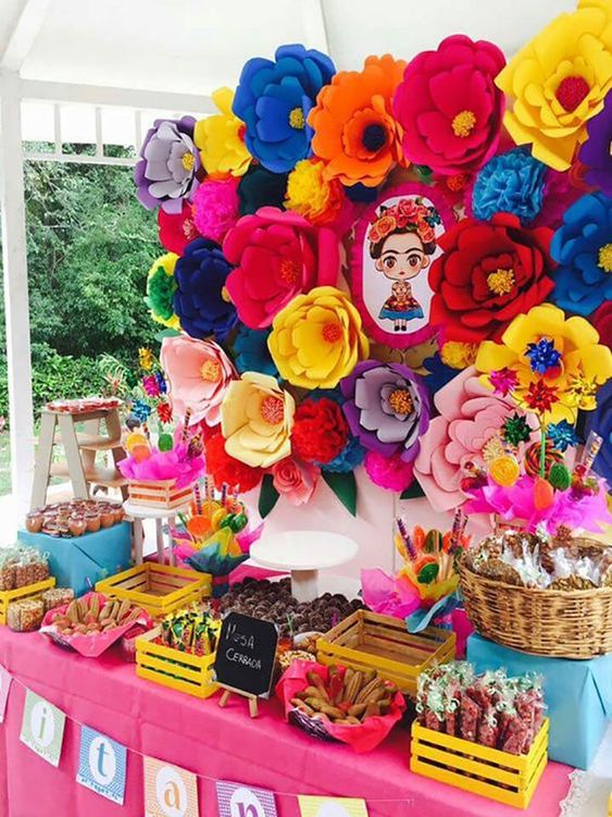 Quinceanera party decorations, a table topped with lots of colorful paper flowers
