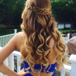 A woman with long blonde hair wearing a blue dress, showcasing Quinceanera hairstyles for homecoming.