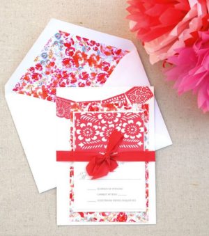 A beautiful red and white Quinceanera invitation with a red ribbon, featuring a paper Charro design.