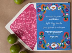 A Quinceanera Invitation, a blue and pink invitation on a table with limes