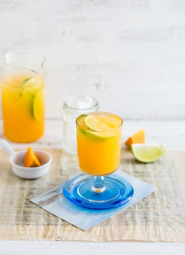 A refreshing Quinceanera drink: a glass of orange juice with a slice of lime