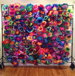 A large multicolored Tissue Paper Mexican flower wall decoration on a wall
