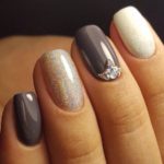 Quinceanera themed image of great nail designs. The image showcases a woman's hand with a gray and white manicure.